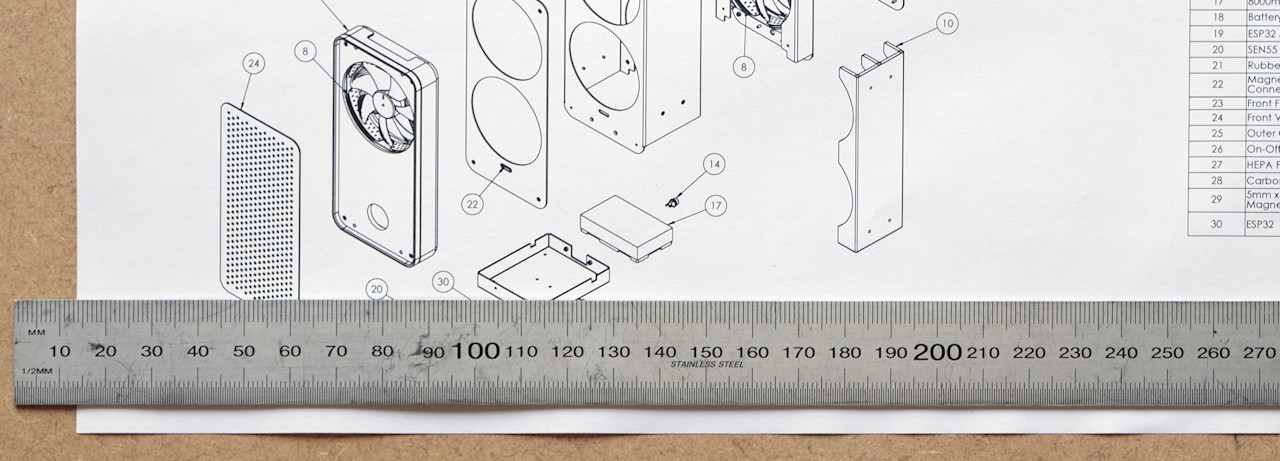 Metal ruler and technical drawing showing an exploded diagram of a air purifier